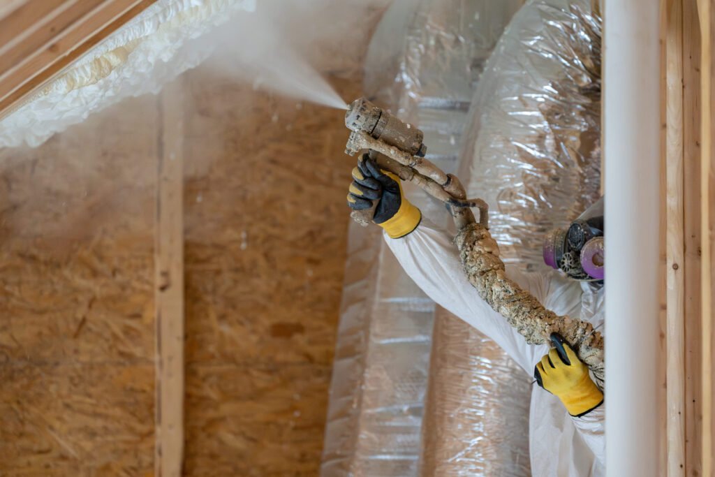construction worker spraying house insulation